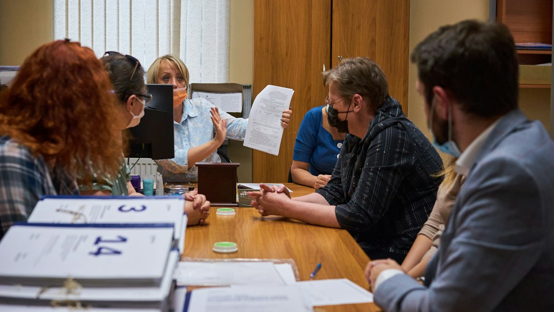 Faculty members in a committee meeting reviewing assessment documents together