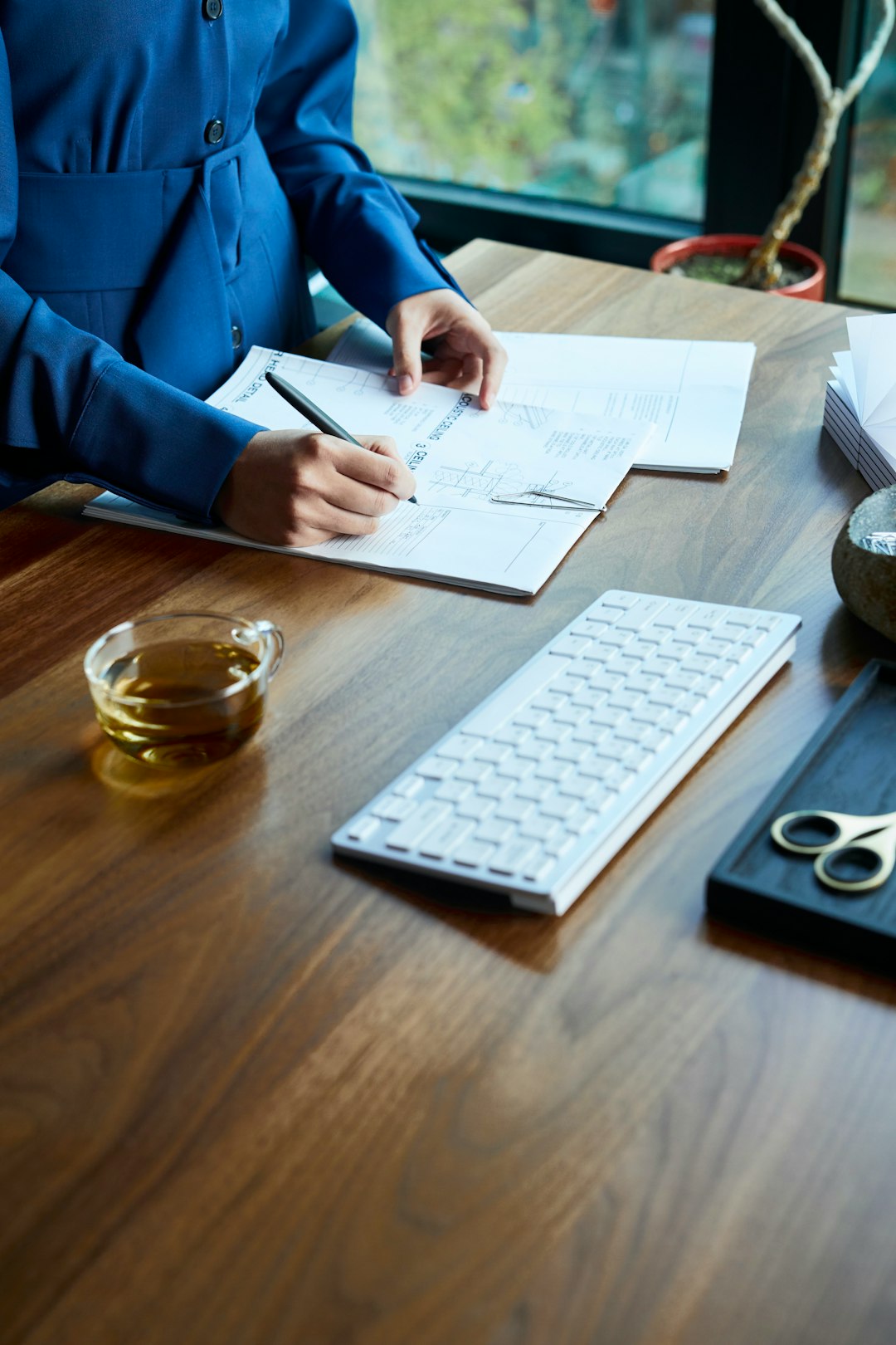Hands completing a self-study document at a desk
