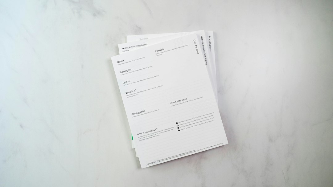 A stack of blank accreditation forms on a desk