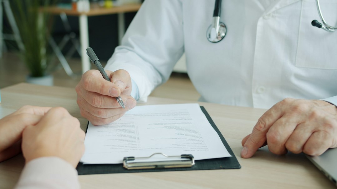 A healthcare professional completing an evaluation form on a clipboard
