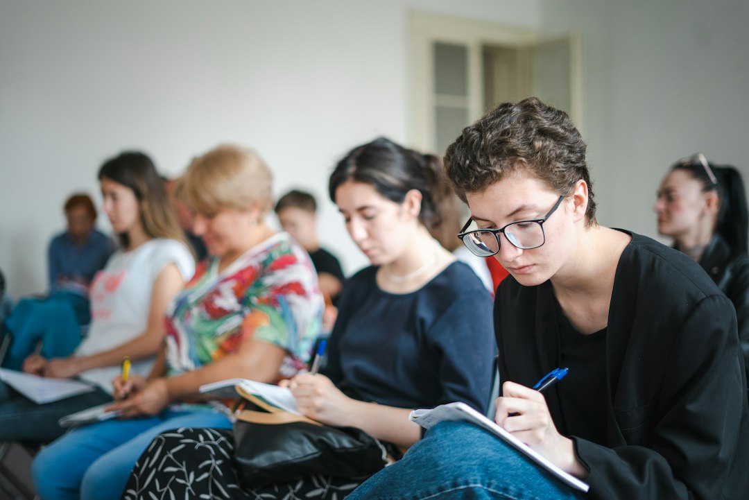 Students writing in notebooks during a university lecture