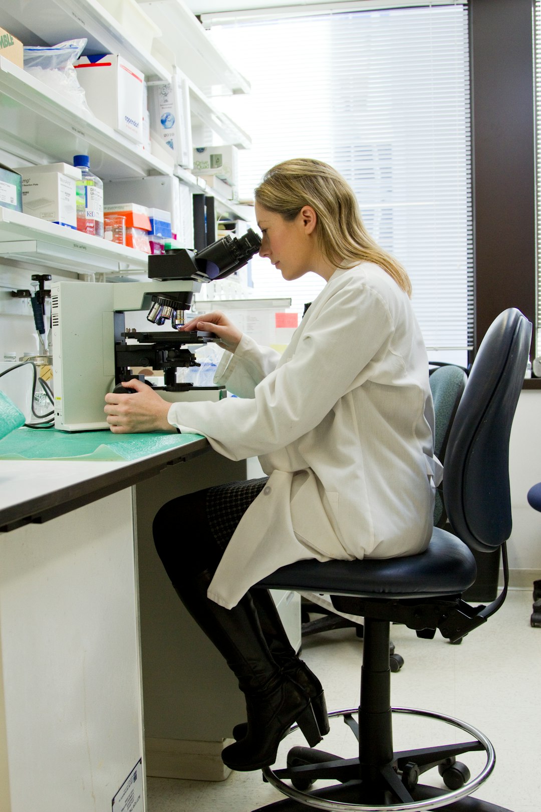 A pharmacy student using a microscope in a university laboratory