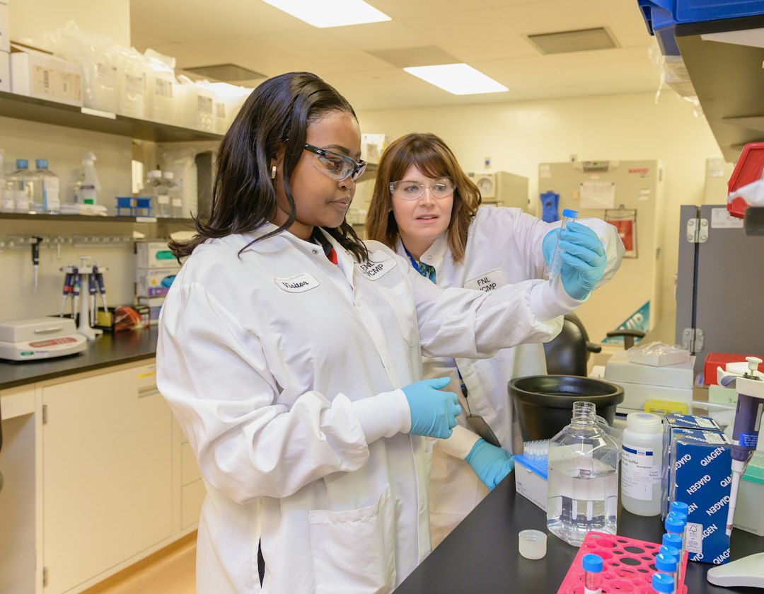Two students in white lab coats working together at a laboratory bench