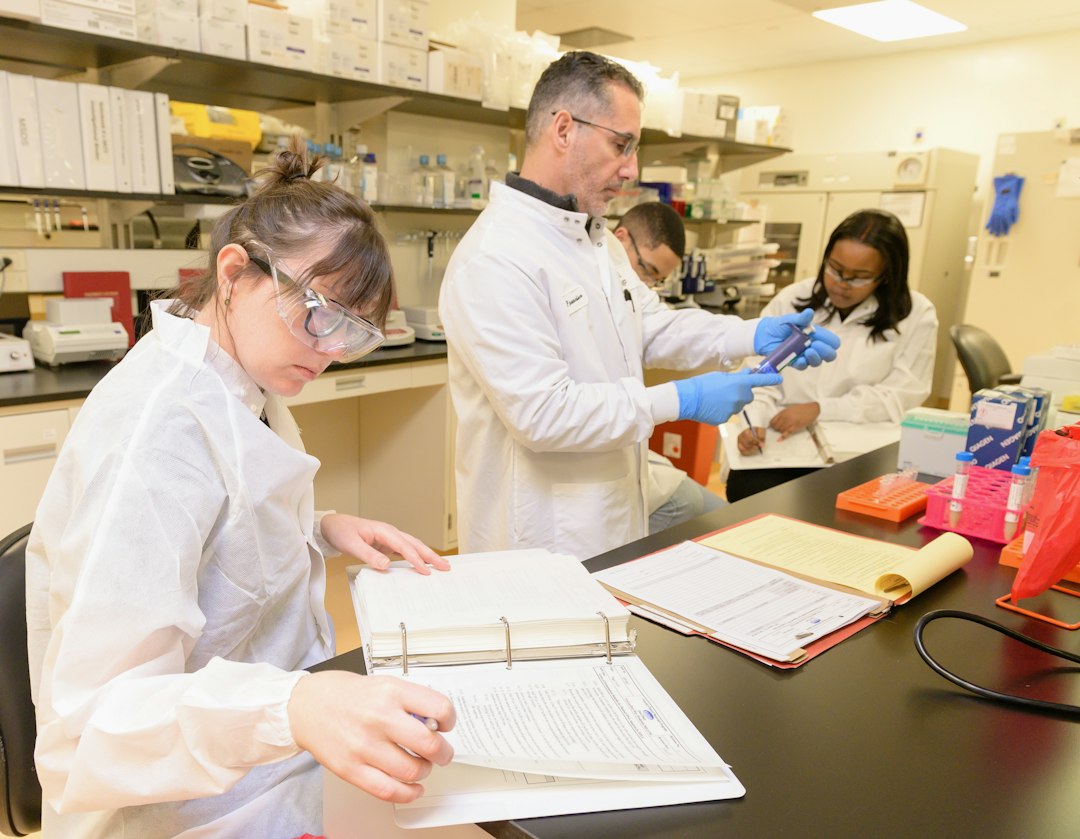 Pharmacy students reviewing an open binder of documents during a lab session