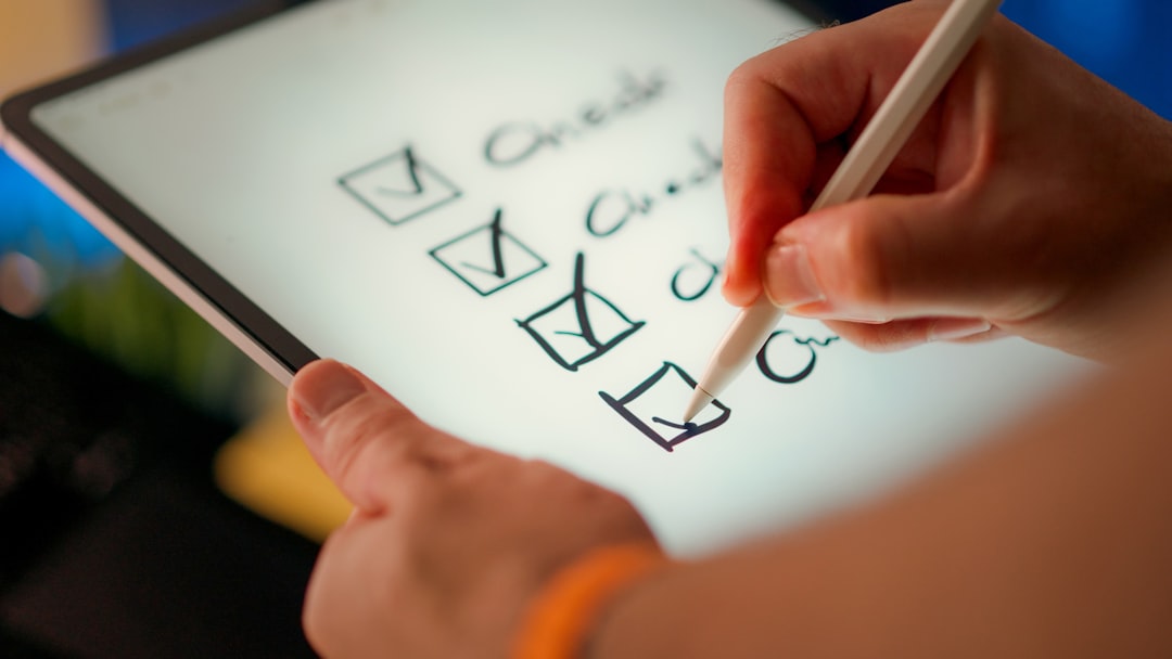 A hand marking off items on a paper checklist with a pen